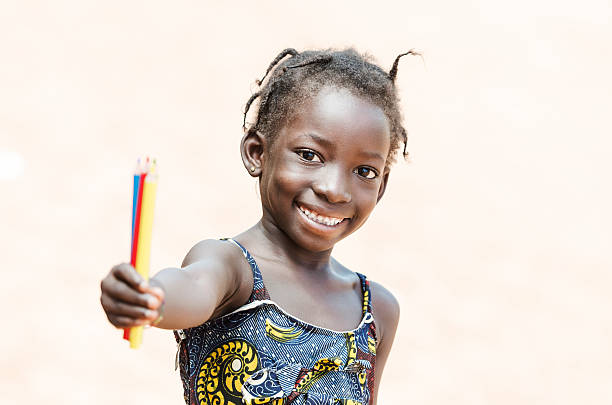 süße afrikanische kleine mädchen mit farbe stifte für school symbol - child thinking writing little girls stock-fotos und bilder