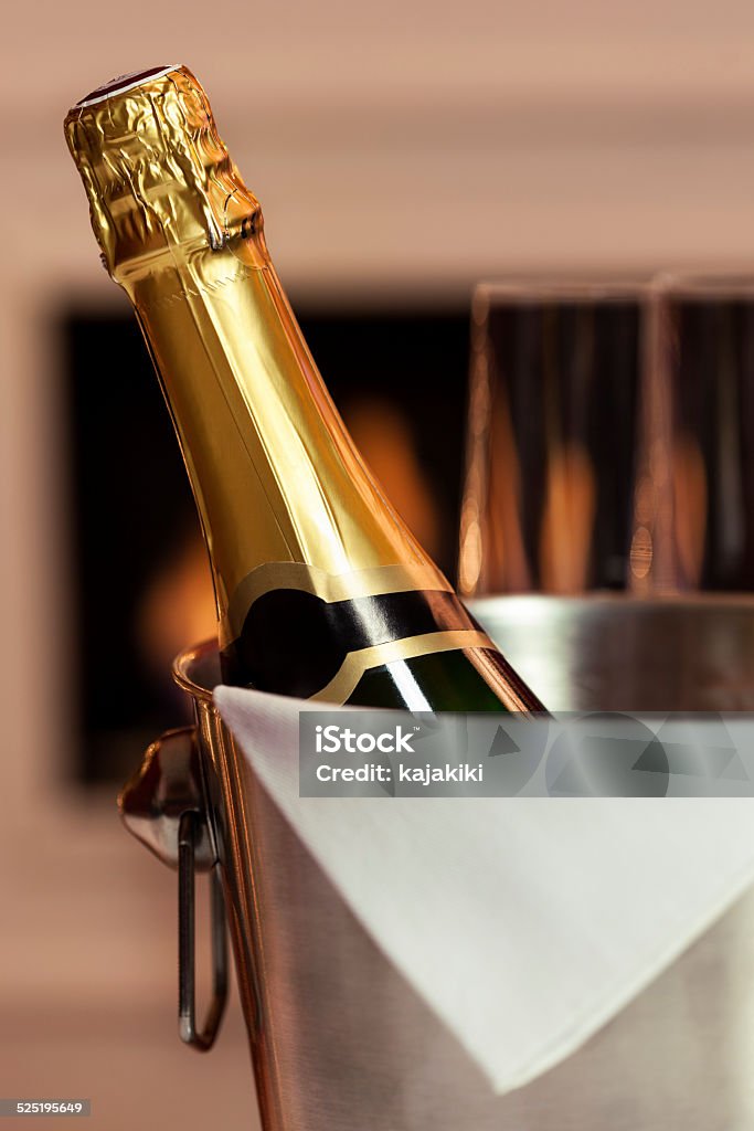 Champagne Champagne bottle in ice bucket in front of the fireplace Champagne Stock Photo