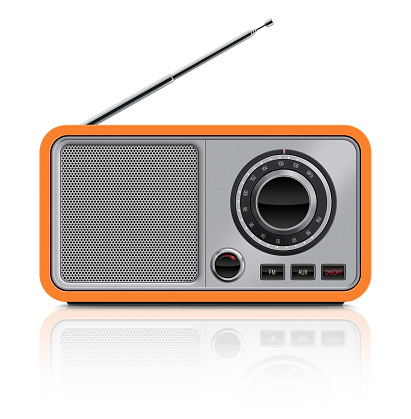 Front view of stylish, retro design table radio which received FM and AM bands. Radio has a orange plastic body, big tuning wheel, metallic front panel and speaker grille, buttons and metallic antenna. Clean image and isolated on white background.