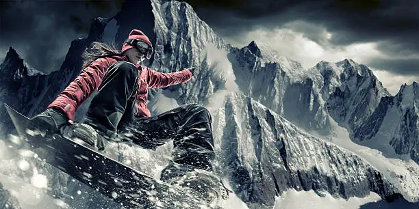 A cross processed close up image of female extreme snowboarder in mid motion, performing trick jump. Action takes place high up in snowy mountains under a dark stormy sky. The snowboarder is wearing generic kit, and the snowboard is unbranded. The location is created in Photoshop. With intentional spray effects. 