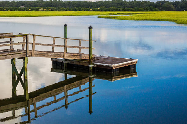 istock Boat Dock reflecting in inlet marsh water 525197789