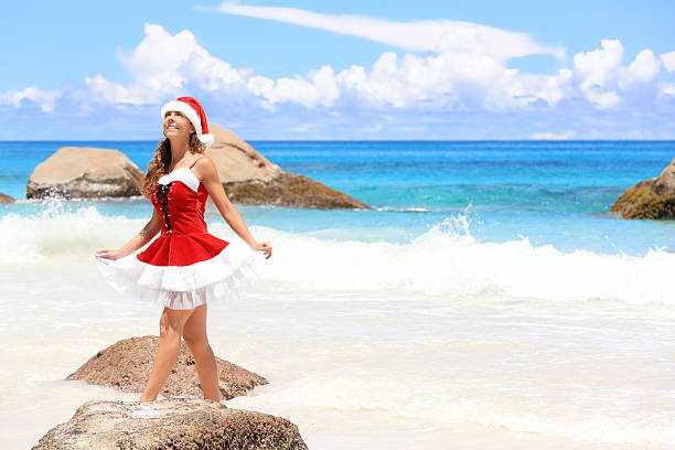 Christmas on the beach Attractive woman with Santa Claus suit sunbathing on the beach, Praslin Island, Seychelles. beautiful multi colored tranquil scene enjoyment stock pictures, royalty-free photos & images