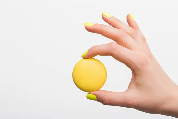 Photo of Person holding yellow macaroon