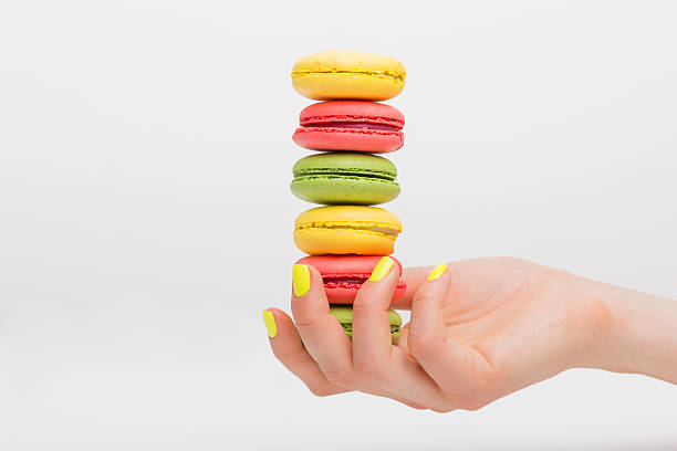 Person holdin macaroon sweets