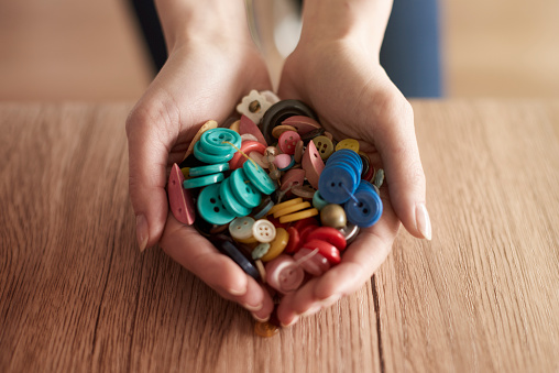 Hands full of colorful buttons
