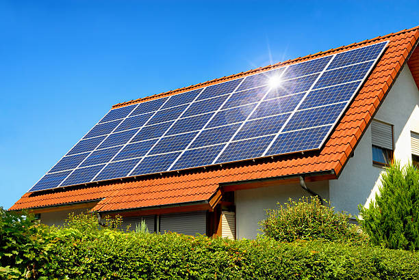 Solar panel on a red roof Solar panel on a red roof reflecting the sun and the cloudless blue sky Solar Energy stock pictures, royalty-free photos & images