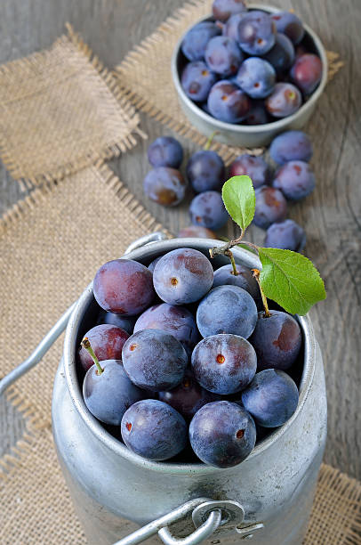istock Fresh plums in bowl on the wooden table, top view 525207542