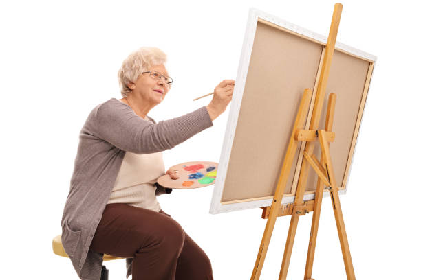 istock Elderly lady painting on a canvas 525208810