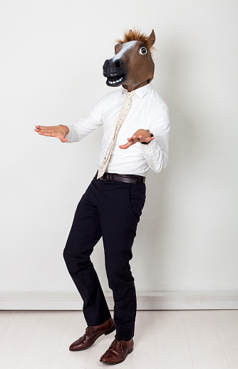 Weird businessman portrait wearing horse head and gesturing