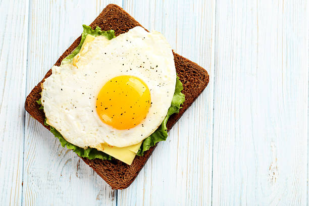 istock Fried eggs with toasts on blue wooden table 525208952