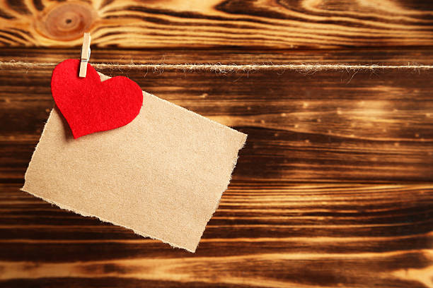istock Blank paper hanging on rope on brown wooden background 525210356