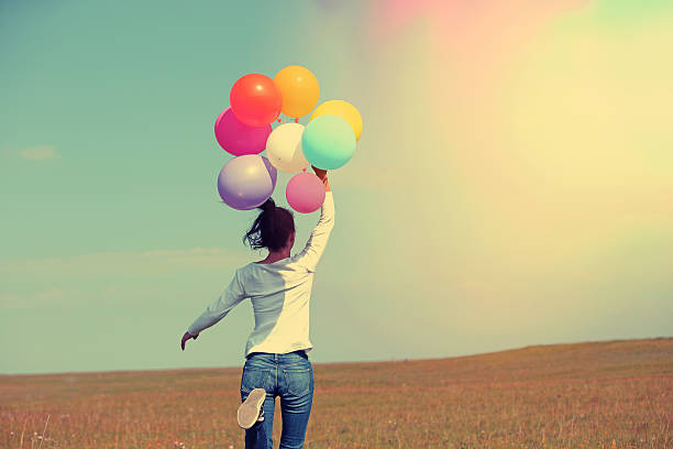 istock young asian woman  with colored balloons 525211181