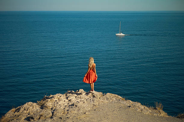 Young woman waiting for sailboat stock photo