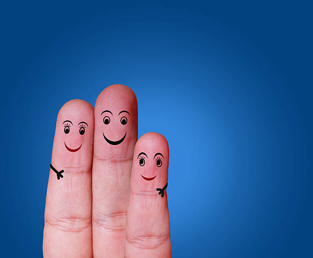 istock Close-up of three fingers painted with smiley face 525217811