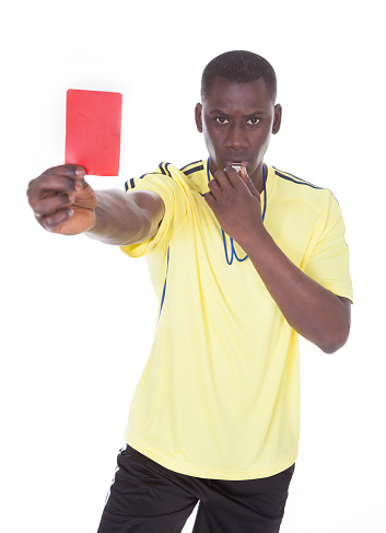 African Referee Holding A Red Card With Whistle In His Mouth