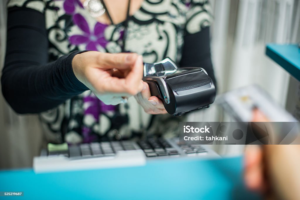 Paying with credit card Handing a credit card to salesperson. Punch Card Reader Stock Photo