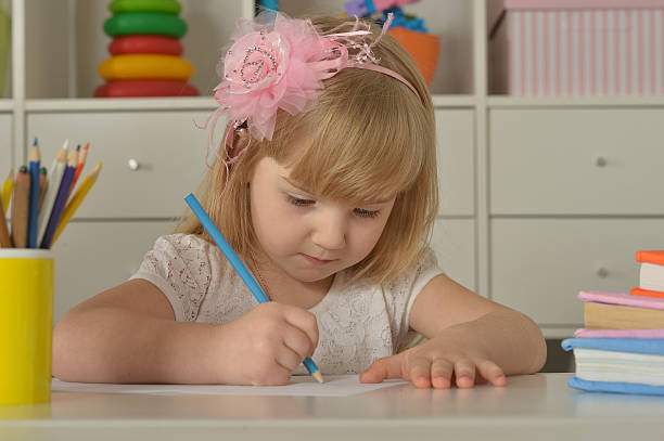 istock Little girl drawing at home 525220176