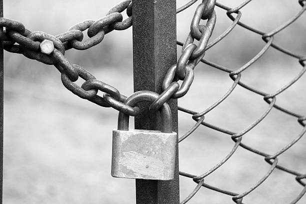 istock iron padlock on iron fence with a chain-link fencing 525221454