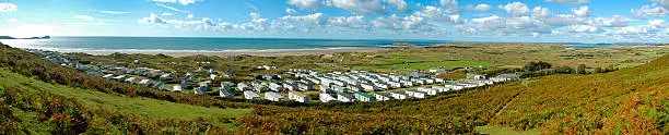 Panoramic view of the British holiday lodges / cabins / huts in a typical British and Welsh camping site by the sea. 
