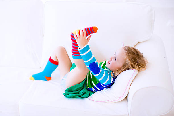 istock Little girl putting on socks 525222517