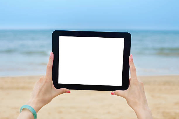 istock Woman Holding Digital Tablet At Beach 525223841