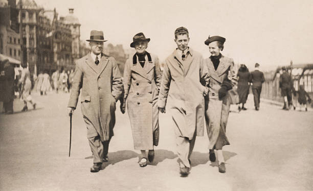 Vintage / retro black-and-white image, 1930s family walking along Weymouth promenade Photo of a vintage / retro photo, showing a family from the 1930s walking along the seafront / promenade in Weymouth on an autumnal day, weather long coats, hats and scarves.  This black and white photograph was taken in 1936, when the Weymouth promenade was much wider.  Many of the hotels and buildings along this seaside thoroughfare are still standing today and look virtually identical. dorset england photos stock pictures, royalty-free photos & images