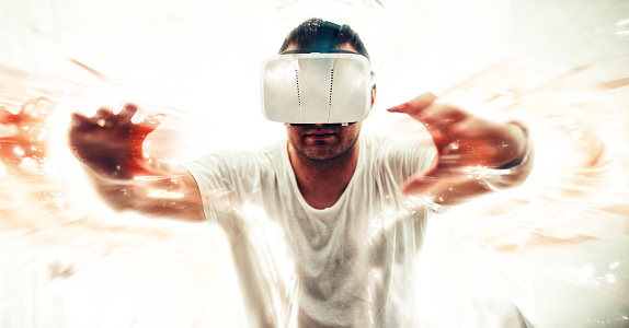 Excited guy using a VR headset and having fun deep in his own virtual world