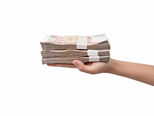 istock Hand giving Thai banknotes, isolated on white background 525233072