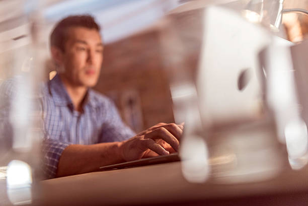 Mid adult creative man sitting in the office and working on a computer.