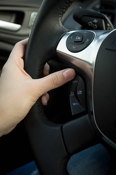 istock Closeup of female driver adjusting cruise control system on stee 525235692