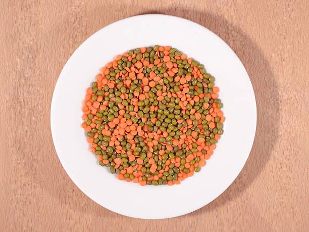 Green mung beans and red raw lentil on white plate