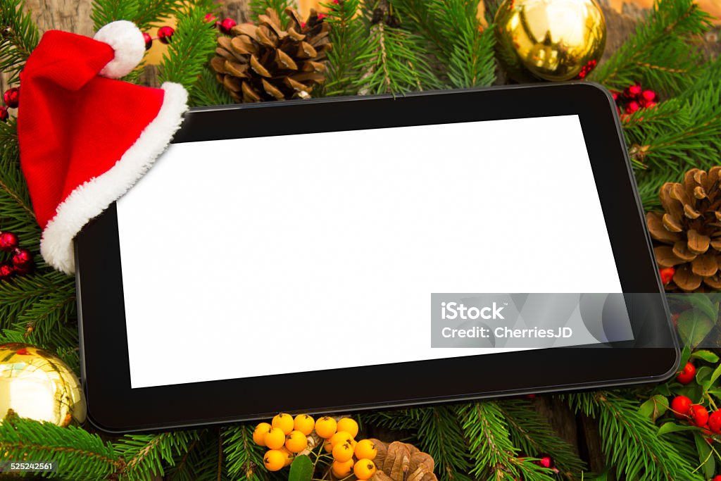 Digital tablet with Santa hat Digital tablet with Santa hat on Christmas fir tree Branch - Plant Part Stock Photo