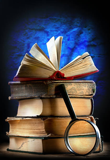 istock Old books with magnifying glass 525243959
