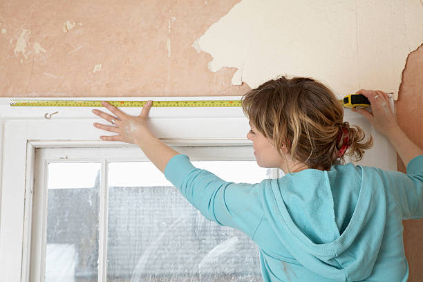 Woman Measuring Window Frame With Tape stock photo