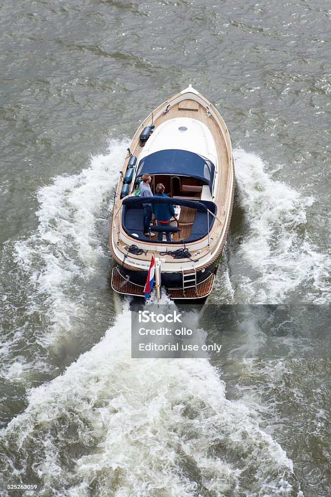 Pleasure craft Rotterdam, The Netherlands - June 18, 2014: Two young men on a Dutch pleasure craft on river Nieuwe Maas, nearby the city center of Rotterdam Day Stock Photo