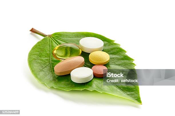 Vitamins And Pills On A Green Leaf Stock Photo - Download Image Now - Nutritional Supplement, Vitamin, Herbal Medicine