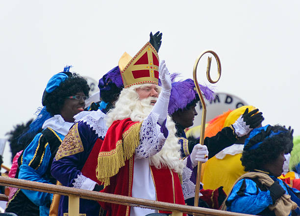 Sinterklaas and Zwarte Pieten on the Steamboat Kampen, The Netherlands - November 15, 2014: Sinterklaas and his black petes arriving on his steamboat in the city of Kampen, The Netherlands. Sinterklaas and his black helpers are waving to the children who are waiting for the old bishop to arrive. zwarte piet stock pictures, royalty-free photos & images