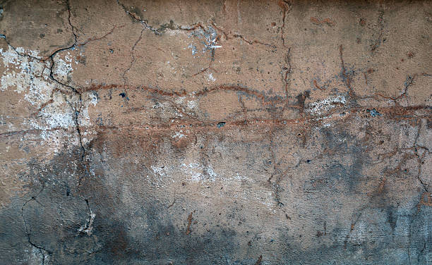 istock Texture of old wall covered with yellow stucco 525272171