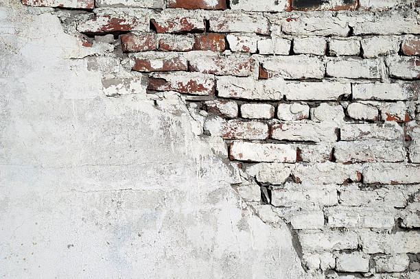 istock Texture of old red brick wall covered with cement 525272187