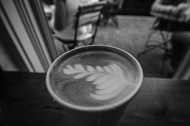 istock Black and White Coffee Latte art on Table by Window 525276051