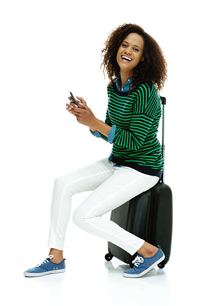 istock Cheerful woman on trolley bag & using mobile 525297847