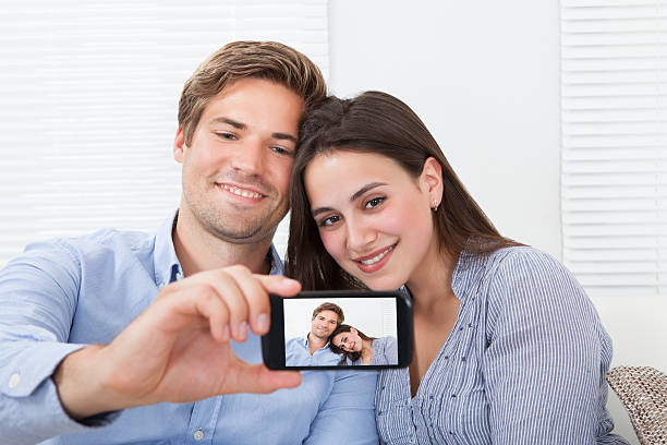 istock Couple Taking Self Portrait Through Smartphone At Home 525299161