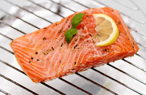 istock Marinated salmon fillet with lemon on grill 525299801