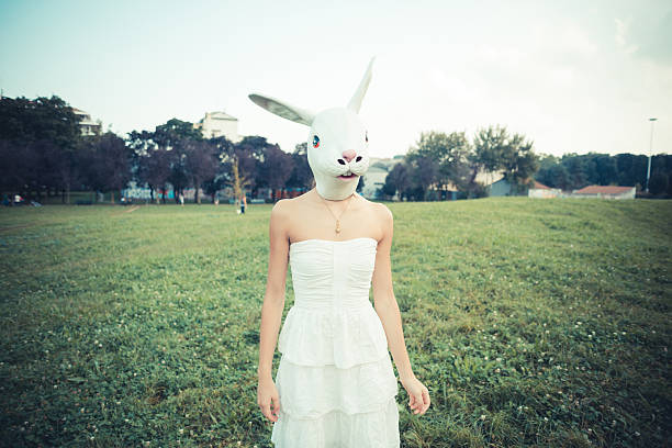 кролик маска абсурдных красивая молодая женщина с белое платье - garment fragility women skirt стоковые фото и изображения