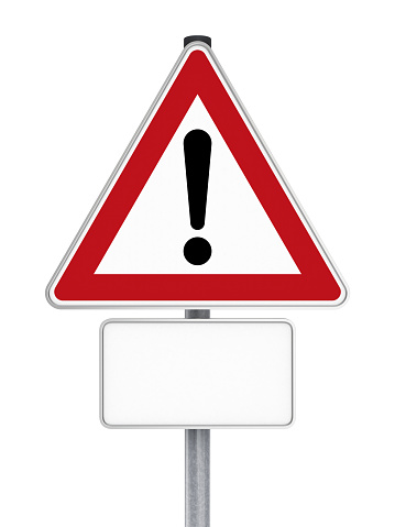 A triangle shaped warning road sign showing an exclamation mark (\