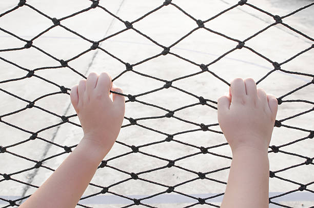 istock Hands with net, Hands with rope mesh fence 525316349