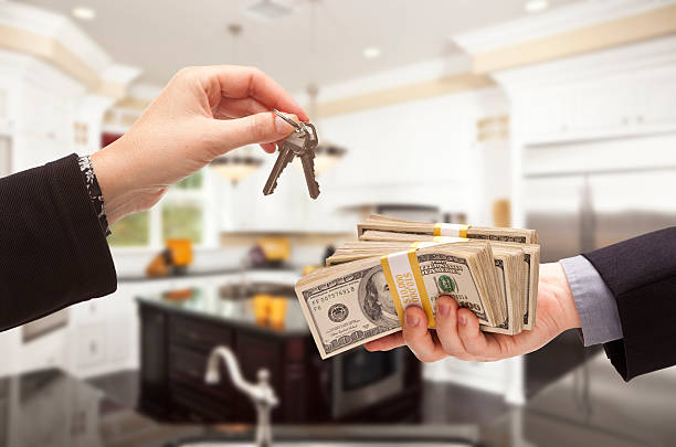 istock Handing Over Cash for Keys Inside Beautiful Home 525318263