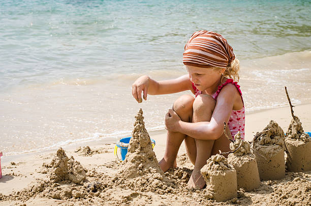istock girl building sand castles 525320455