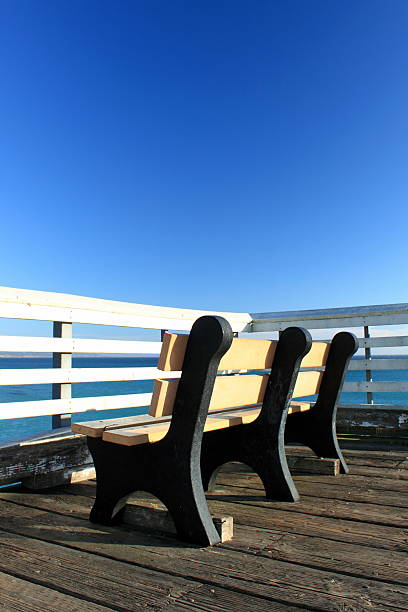 istock Bench on a pier with ocean in background 525320589