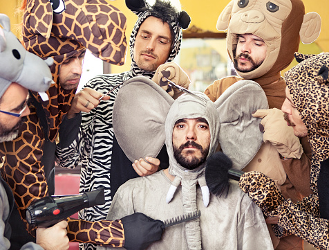 Hairdressers styling a man dressed up as an elephant